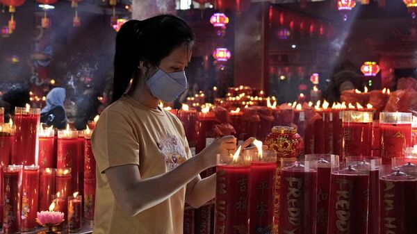 Зажжение свечи в храме во время празднования Нового года по лунному календарю в Индонезии  - Sputnik Грузия