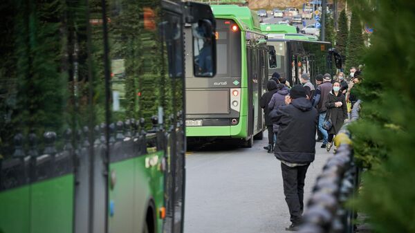 Автобусная остановка и люди в масках во время эпидемии коронавируса - Sputnik Грузия