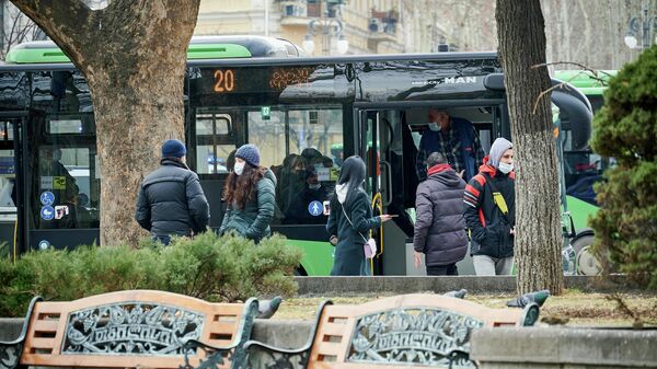 Автобусная остановка и люди в масках во время эпидемии коронавируса - Sputnik Грузия