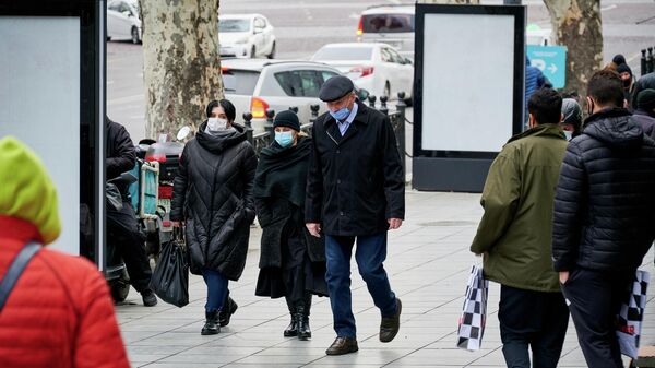 Эпидемия коронавируса - прохожие на улице в масках у торгового центра - Sputnik Грузия