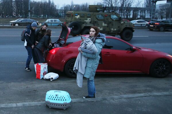 Жители Киева на одной из улиц украинской столицы складывают вещи в машину, чтобы покинуть город. - Sputnik Грузия