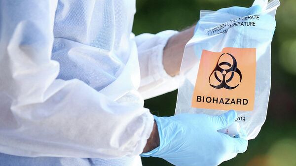 Медицинский работник держит в руках пакет с биологически опасными веществами - Sputnik Грузия