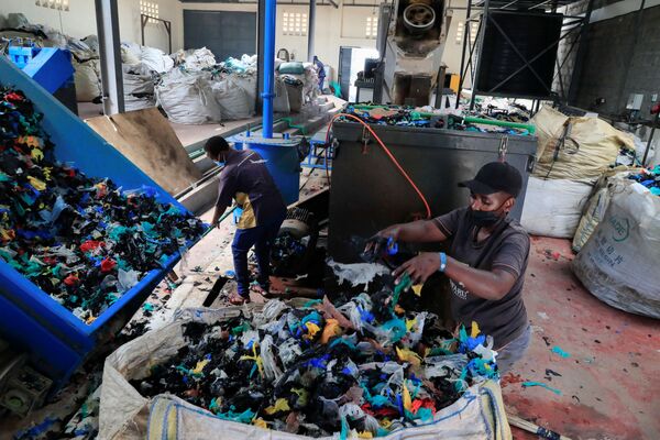 Работники очищают пластиковые пакеты на заводе по переработке пластика возле свалки Дандора - Sputnik Грузия