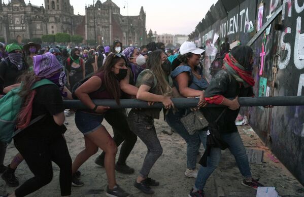 Женщины пытаются сломать забор, закрывающий Национальный дворец, во время демонстрации в честь Международного женского дня в Мехико - Sputnik Грузия