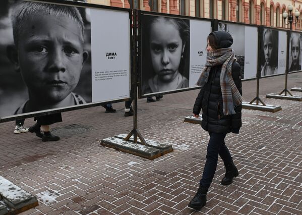 Девушка на улице Арбат в Москве, где открылась фотовыставка &quot;Посмотри в глаза Донбассу&quot;, на которой представлены фотографии детей из зоны боевых действий в Донбассе - Sputnik Грузия