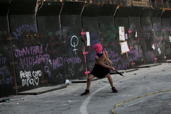 Женщина бросает мусор в забор во время акции протеста по случаю Международного женского дня в Мехико - Sputnik Грузия