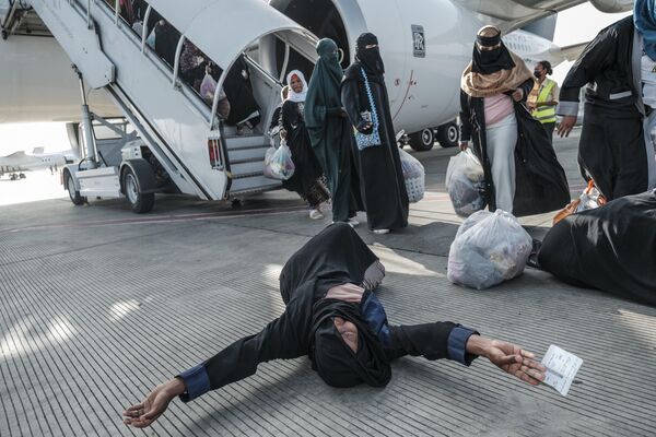 Эфиопская женщина, репатриированная из Саудовской Аравии, высаживается из самолета в аэропорту Боле в Аддис-Абебе - Sputnik Грузия
