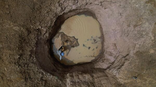 Мужчина роет яму в высохшем русле реки недалеко от деревни Тата Батили в Матаме, Сенегал, 30 марта 2022 года - Sputnik Грузия