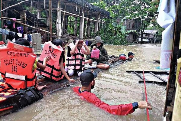 Спасатели эвакуируют жителей из затопленной деревни в Панитане на Филиппинах. Проливные дожди, вызванные летней тропической депрессией, убили по меньшей мере несколько человек в центральной части острова - Sputnik Грузия