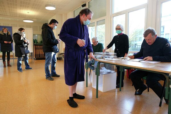 Избиратель в халате и тапочках голосует на избирательном участке в Реймсе, на северо-востоке Франции, во время первого тура президентских выборов 10 апреля 2022 года - Sputnik Грузия