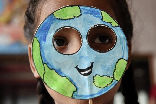 Ученик надевает маску, сделанную в форме планеты Земля, во время мероприятия по случаю &quot;Дня Земли&quot;  - Sputnik Грузия