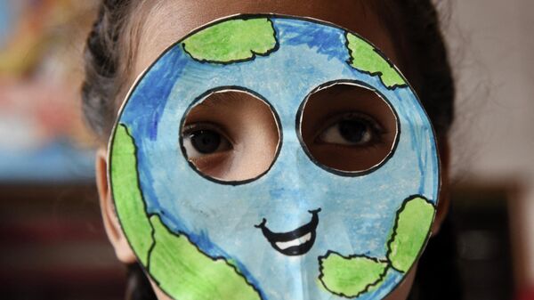 Ученик надевает маску, сделанную в форме планеты Земля, во время мероприятия по случаю Дня Земли в школе в Амритсаре, Индия - Sputnik Грузия