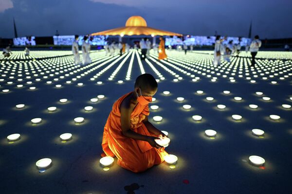 Молодой буддийский монах устанавливает светодиодный светильник в рамках празднования &quot;Дня Земли&quot; в буддийском храме Ват Дхаммакая в провинции Патхумтхани - Sputnik Грузия