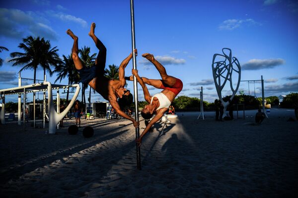 Наталья Номада и Оскар выполняют акробатический элемент с шестом на песке в Майами-Бич - Sputnik Грузия