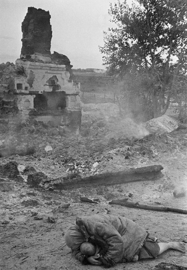Мать укрывает своего ребенка во время обстрела. Деревня Красная слобода, Брянский фронт 1941 год - Sputnik Грузия