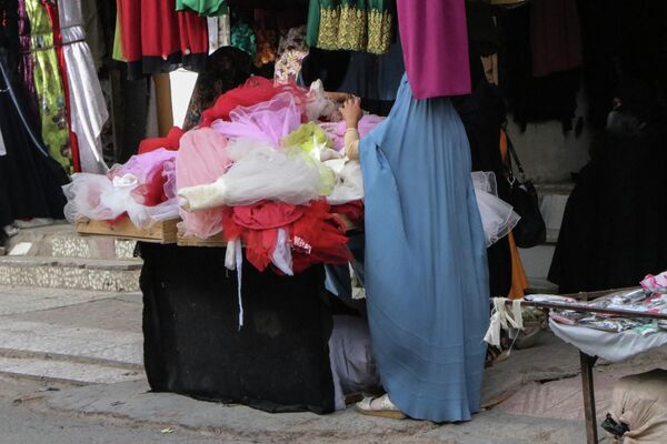 Женщина в парандже выбирает детскую одежду в магазине в Герате - Sputnik Грузия
