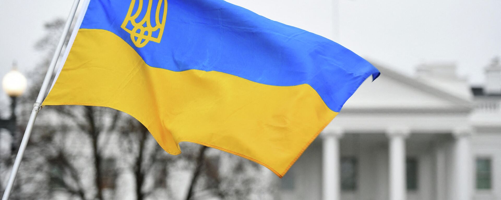 Флаг Украины с гербом развевается, когда активисты собираются на площади Лафайет в знак протеста против российского вторжения в Украину в Вашингтоне - Sputnik Грузия, 1920, 14.06.2022