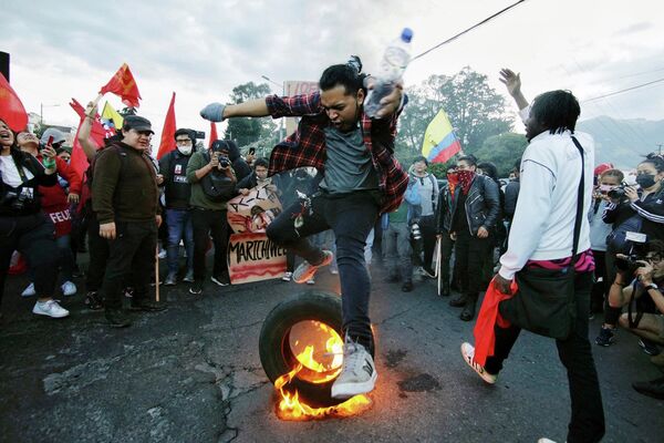 Студент университета прыгает через горящую покрышку во время демонстрации против президенства Гильермо Лассо  - Sputnik Грузия