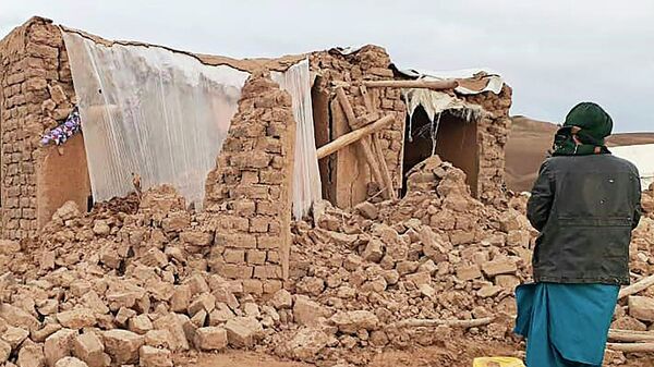 Житель стоит возле разрушенного землетрясением дома в районе Кадис в южной части провинции Бадгис (18 января 2018). Афганистан - Sputnik Грузия