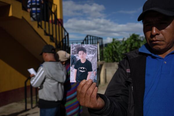 Житель Гватемалы показывает фото погибшего родственника. Власти этой страны уже заявили о том, что подключаются к расследованию гибели мигрантов. - Sputnik Грузия