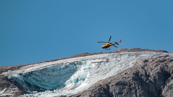 Спасательный вертолет пролетает над ледником, рухнувшим накануне на горе Мармолада, Италия  - Sputnik Грузия
