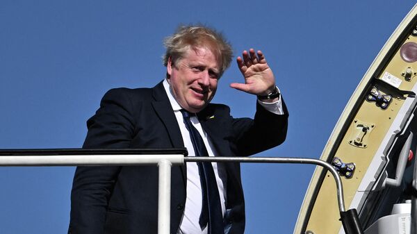 Премьер-министр Великобритании Борис Джонсон машет рукой, садясь в самолет - Sputnik Грузия