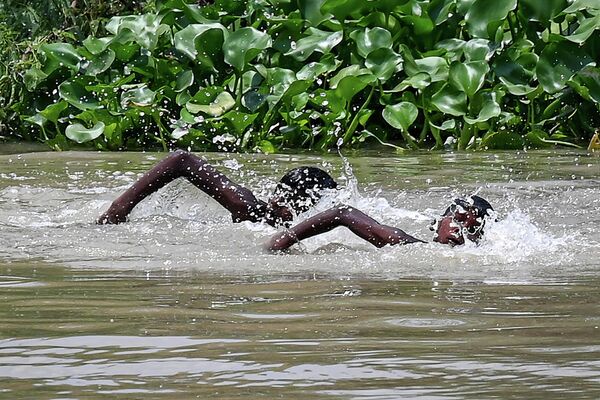 Но есть и наполненные водой водоемы. Дети плавают в канале жарким летним днем в Нью-Дели. - Sputnik Грузия