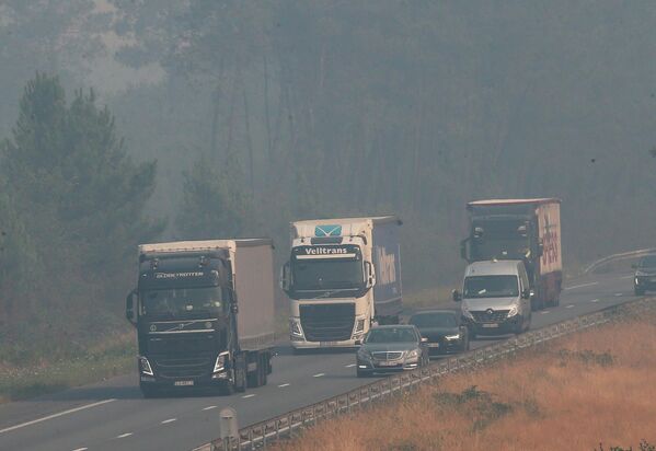 Леса горят во Франции, Испании и Португалии. На фото - во Франции машины едут в клубах дыма от лесных пожаров по одной из главных автотрасс - Sputnik Грузия
