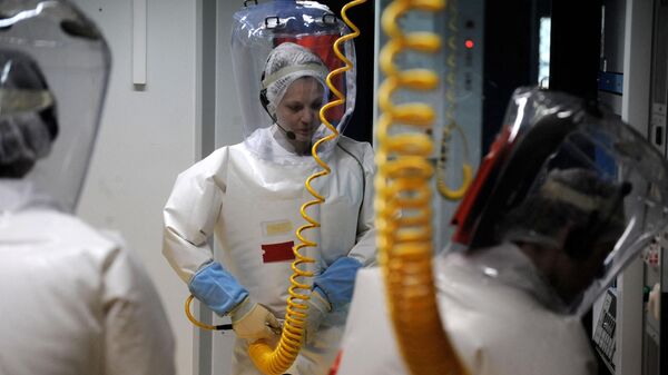 Медик надевает защитный костюм перед входом в палату с зараженными оспой - Sputnik Грузия