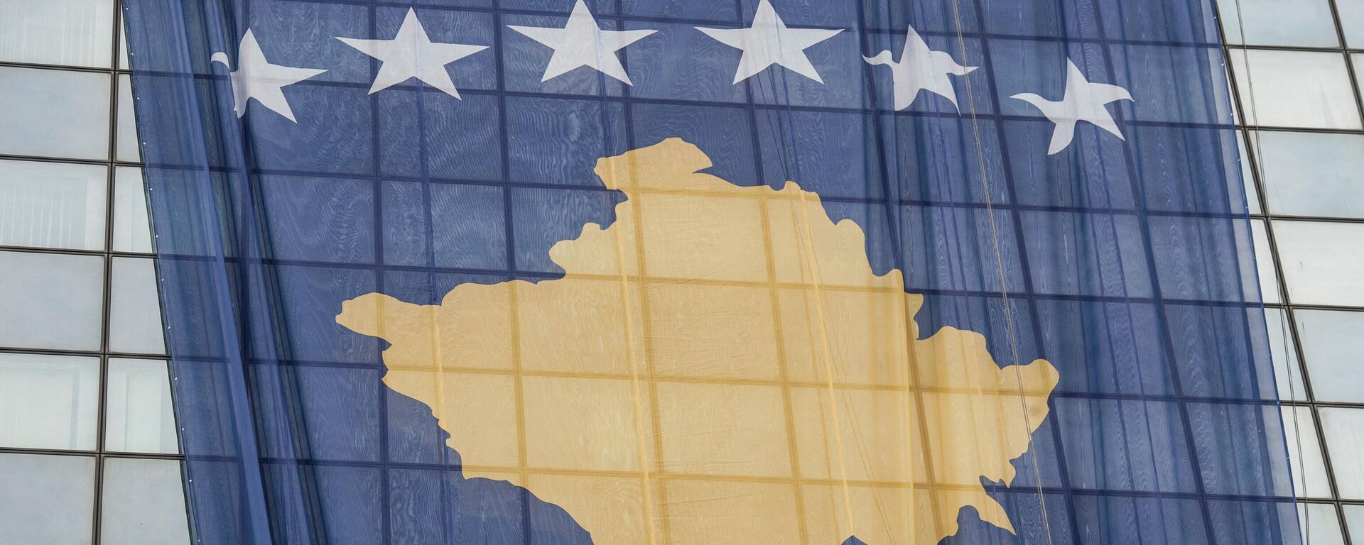 Сотрудник устанавливает гигантский флаг Косово на правительственном здании в Приштине 14 февраля 2018 года в преддверии десятой годовщины независимости Косово. - Sputnik Грузия, 1920, 02.08.2022