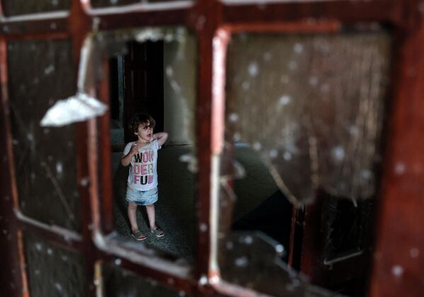 ბავშვი ჩამტვრეული მინის მიღმა შენობაში, რომელიც ავიადარტყმის შედეგად დაზიანდა - Sputnik საქართველო