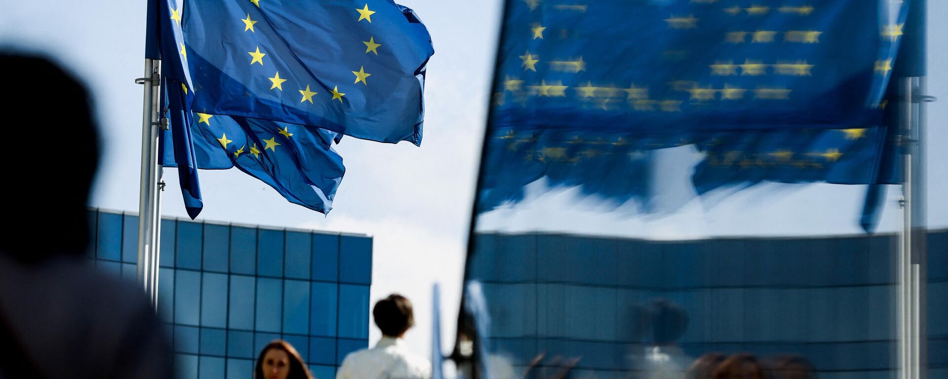 Люди идут перед флагом Евросоюза в районе штаб-квартиры ЕС в Брюсселе 23 сентября 2021 г. - Sputnik Грузия, 1920, 30.08.2022