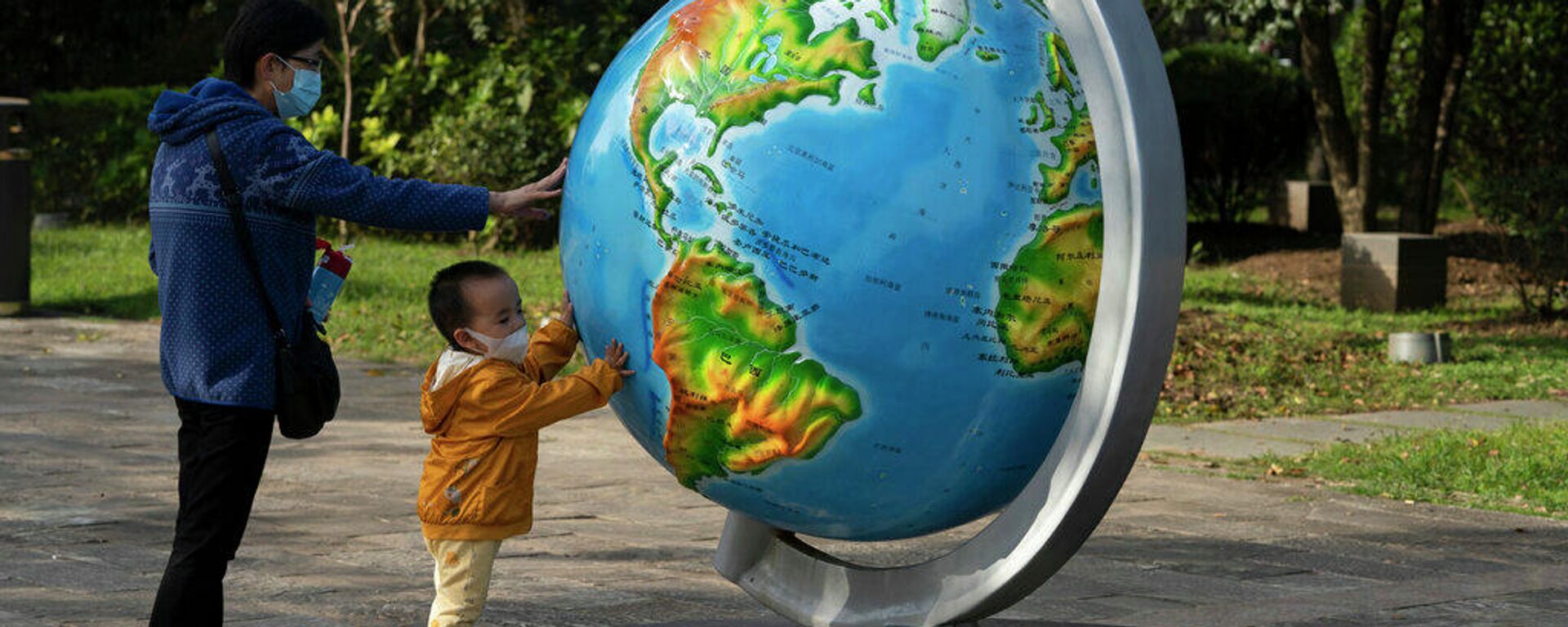 Женщина и ребенок у глобуса в китайском городе Ухань - Sputnik Грузия, 1920, 08.09.2022