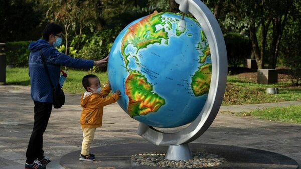 Женщина и ребенок у глобуса в китайском городе Ухань - Sputnik Грузия