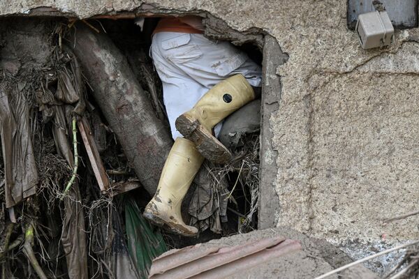 Человек ищет пропавших родственников в разрушенном доме после схода оползня в Венесуэле - Sputnik Грузия