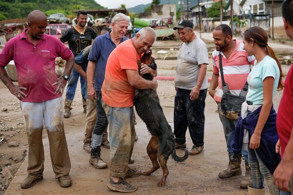 Мужчина воссоединяется со своей собакой, спасенной соседями после наводнения, вызванного сильными дождями в Лас-Техериасе - Sputnik Грузия