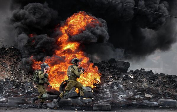 Израильские солдаты во время столкновений с палестинскими демонстрантами после протеста против экспроприации палестинских земель Израилем в деревне Кфар-Каддум - Sputnik Грузия