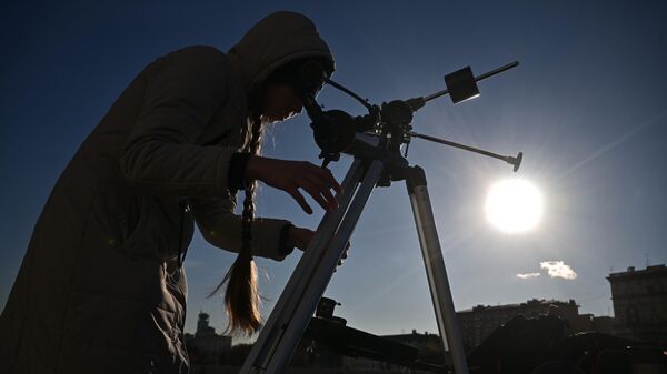 Девушка наблюдает в телескоп частичное солнечное затмение в Москве - Sputnik Грузия