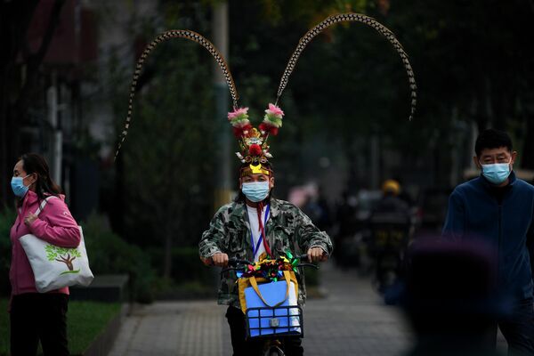 Мужчина в головном уборе Короля обезьян на улице в Пекине - Sputnik Грузия