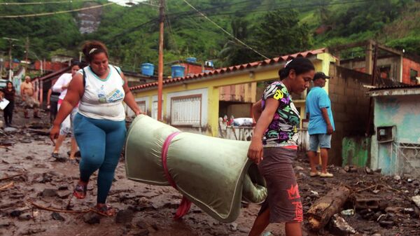 Жители Пуэрто-ла-Крус, Венесуэла, выносят из разрушенных оползнем домов уцелевшие вещи - Sputnik Грузия