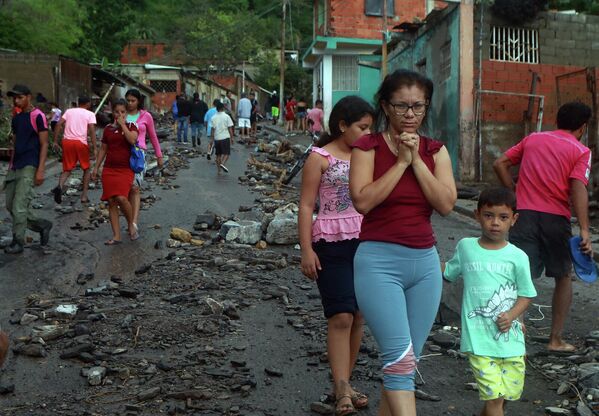 Местные жители на одной из улиц Пуэрто-ла-Крус, Венесуэла, после схода оползня - Sputnik Грузия
