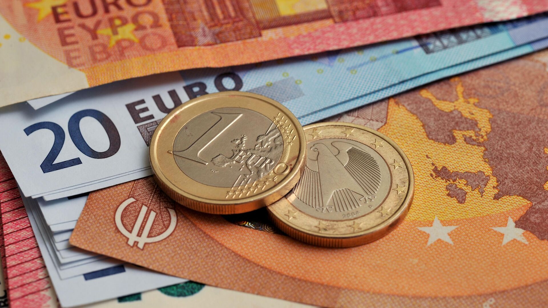 Монеты номиналом 1 евро на фоне банкнот номиналом 10 и 20 евро.  - Sputnik Грузия, 1920, 24.11.2022