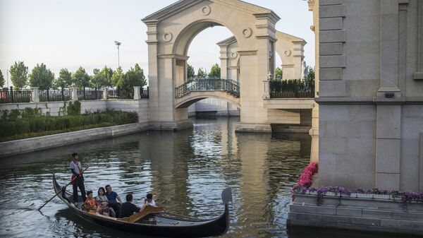 Люди катаются на лодке в китайской Венеции в городе Далянь. - Sputnik Грузия