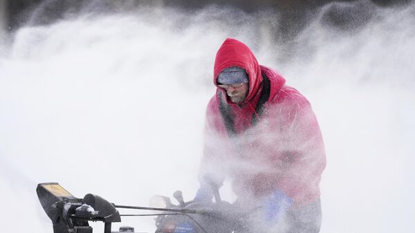 Марк Сортер расчищает снег с ледового катка в центре города в Де-Мойне, штат Айова - Sputnik Грузия