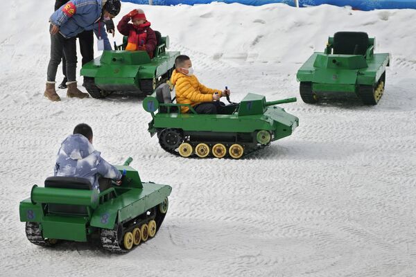 Дети катаются на игрушечных танках по снегу в общественном парке Пекина - Sputnik Грузия