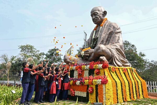 Индийские школьники бросают цветы к монументу Махатмы Ганди  - Sputnik Грузия