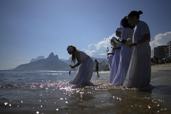 Верующие принимают участие в традиционной церемонии Иеманьи на пляже в Рио-де-Жанейро - Sputnik Грузия