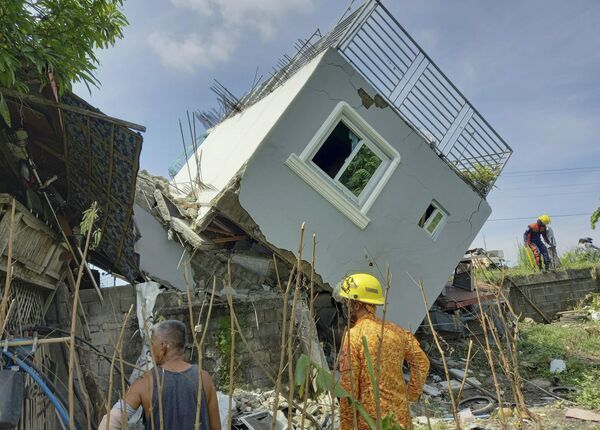 მაშველები ამოწმებენ სახლის დაზიანებულ კედელს სანტიაგოში მომხდარი ძლიერი მიწისძვრის შემდეგ. ფილიპინები, 2022 წლის 27 ივლისი - Sputnik საქართველო