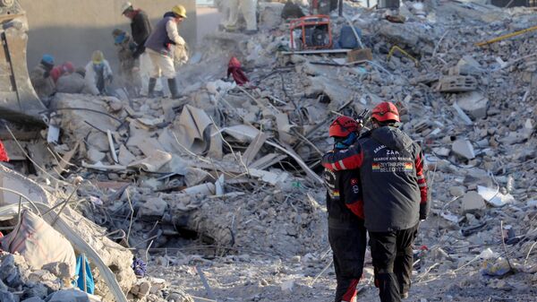 Члены поисково-спасательной группы среди обломков разрушенных зданий в Нурдаги, Турция - Sputnik Грузия