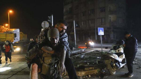 Солдат несет мужчину, получившего ранения в результате последнего землетрясения в Хатае, Турция - Sputnik Грузия